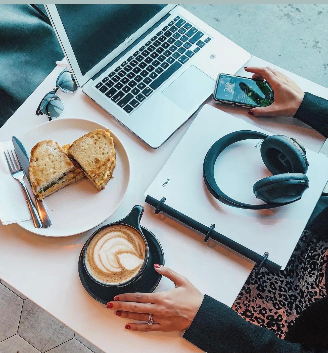 A sandwich and latte beside a laptop at Isaiah Café