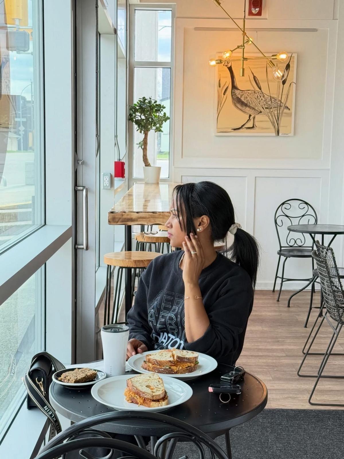 A guest with coffee at the window table of Isaiah Café, 101 19th Street NW