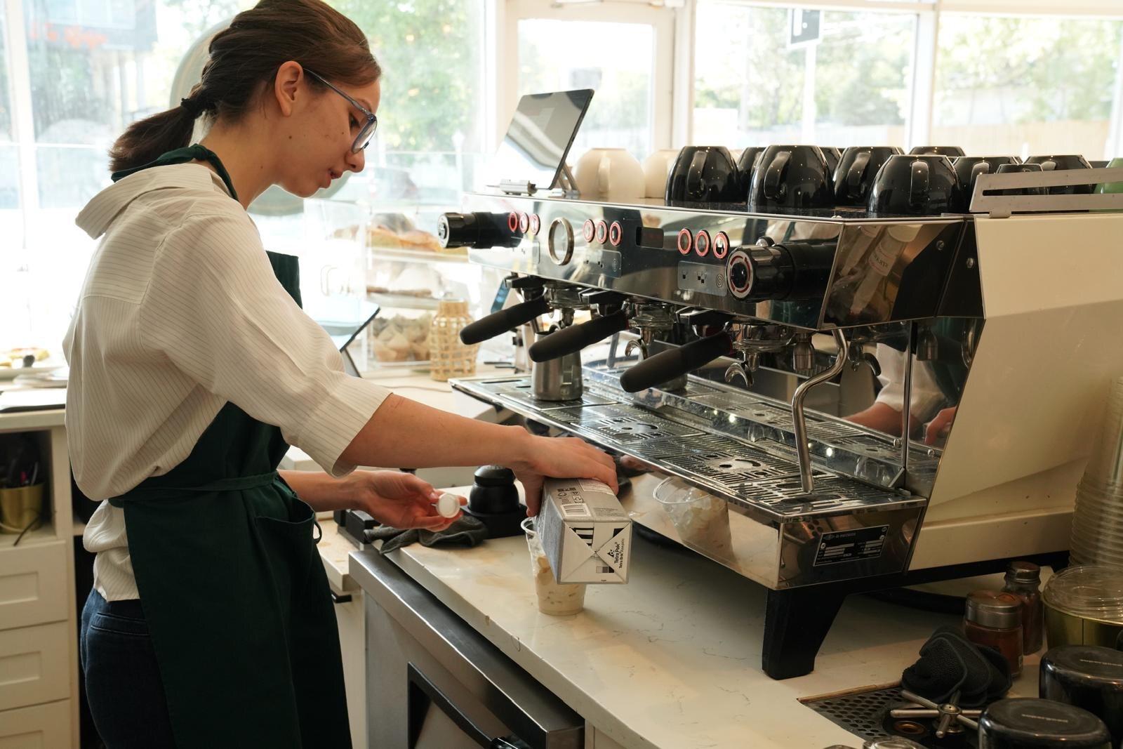 Barista pulling espresso at the Isaiah Café counter in Calgary