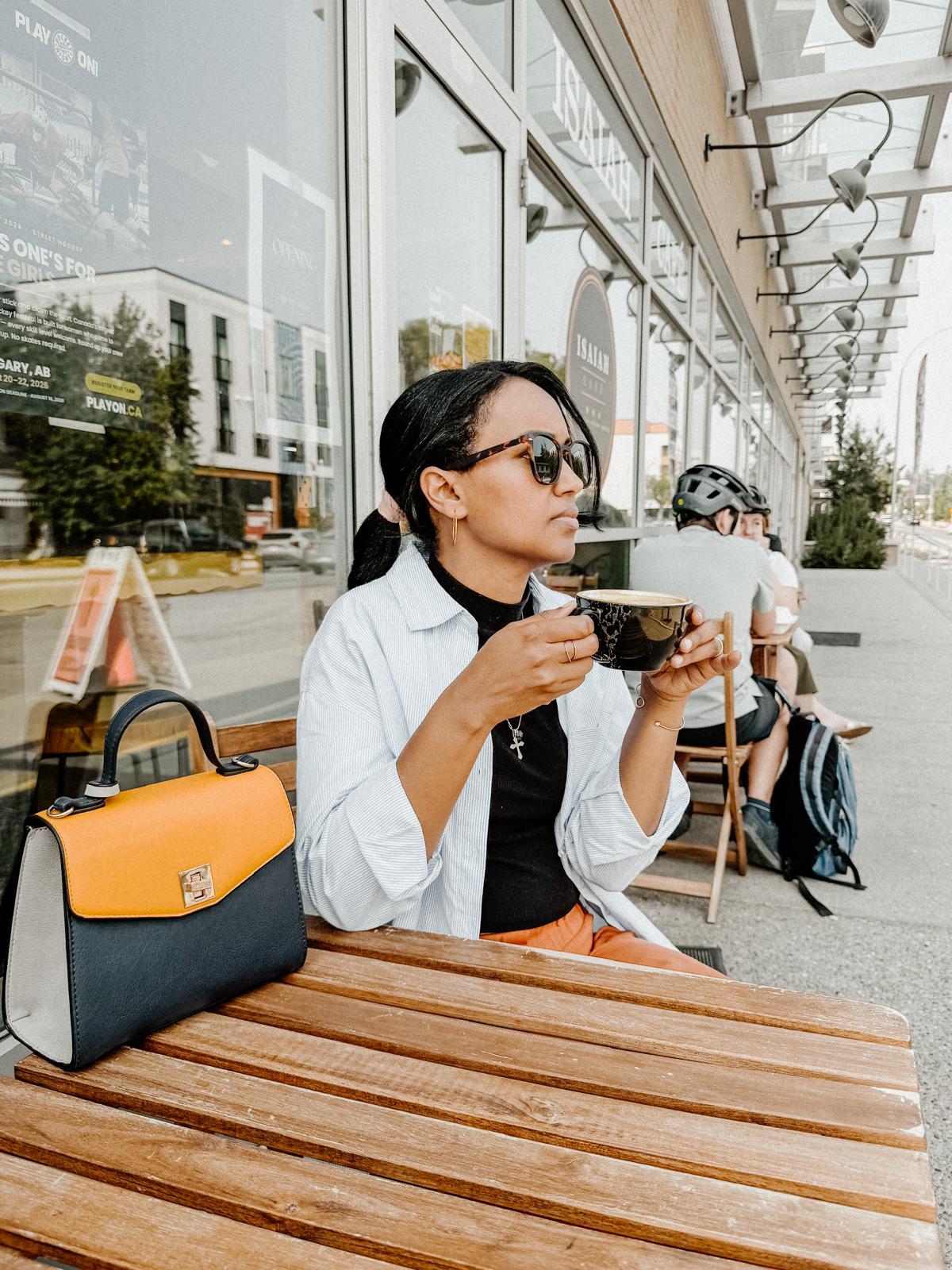 Semhar with a cappuccino on the patio outside Isaiah Café